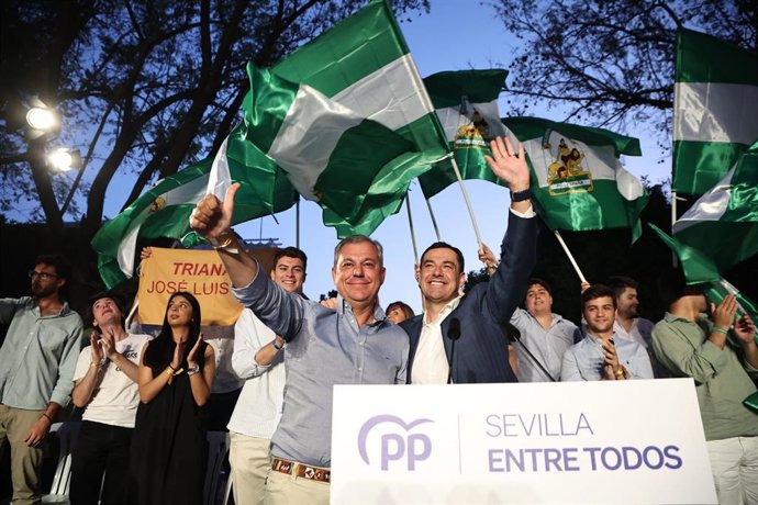 El presidente del PP-A y de la Junta de Andalucía, Juanma Moreno (d), junto a candidato del PP a la Alcaldía, José Luis Sanz (i), durante el acto de cierre de campaña en la Plaza de San Gonzalo de Triana. 