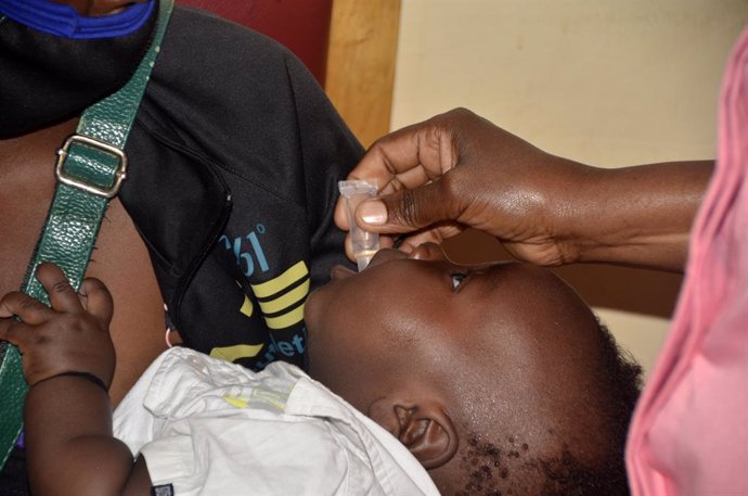 Archivo - Un sanitario da medicamento a un niño en Kampala, Uganda