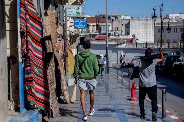 Archivo - Varias personas caminan por una calle con tiendas en Tánger