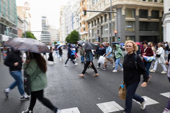 Varias personas pasean bajo la lluvia, a 23 de mayo de 2023, en Madrid (España). La Agencia Estatal de Meteorología (Aemet) prevé lluvias en la región madrileña todo lo que queda de semana ocasionadas por una DANA (Depresión Aislada en Niveles Altos) qu
