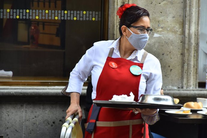 Archivo - MEXICO CITY, MEXICO - JANUARY 20: A restaurant worker serves meals after Mexico's Government allowed the restaurants reopen to operate only outdoors, after the restaurant industry protested against the confinement, although the pandemic contin