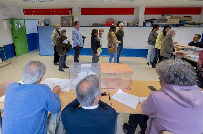 Varias personas hacen cola para ejercer su derecho al voto en el Colegio Público Pinar del Rey