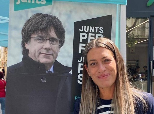 La portavoz de Junts en el Congreso, Míriam Nogueras, delante de un cartel electoral del expresidente de la Generalitat Carles Puigdemont