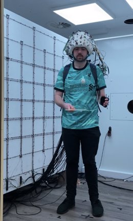 El investigador principal del estudio, Niall Holmes, lleva el casco de imagen cerebral mientras está de pie.