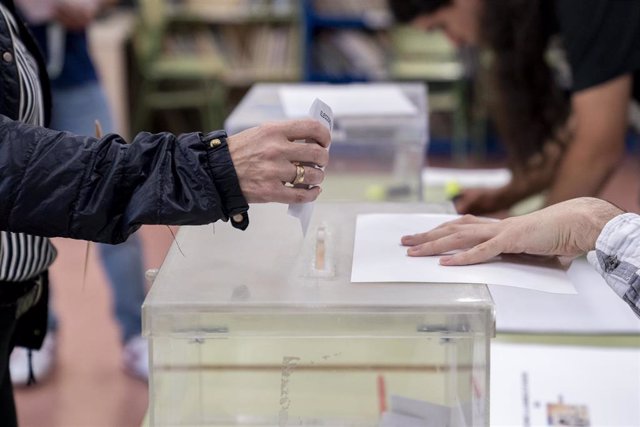 Una persona mete su voto en la urna en un colegio electoral, a 28 de mayo de 2023, en Madrid (España).  Hoy, 28M, se celebran en España elecciones municipales en un total de 8.131 ayuntamientos, elecciones autonómicas en 12 comunidades autónomas y en las 