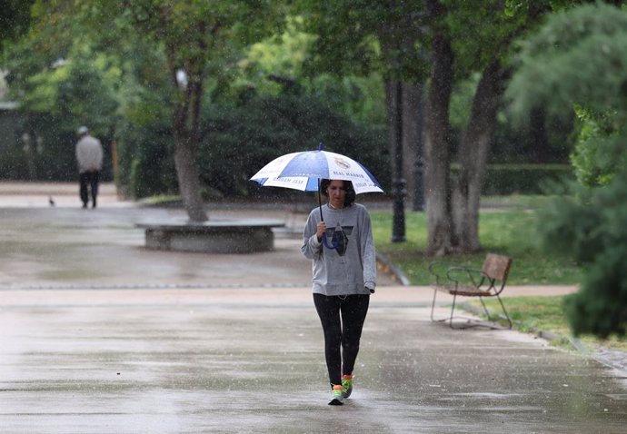 Una mujer pasea por el parque de El Retiro, a 23 de mayo de 2023, en Madrid (España). La Agencia Estatal de Meteorología (Aemet) prevé lluvias en la región madrileña todo lo que queda de semana ocasionadas por una DANA (Depresión Aislada en Niveles Alto