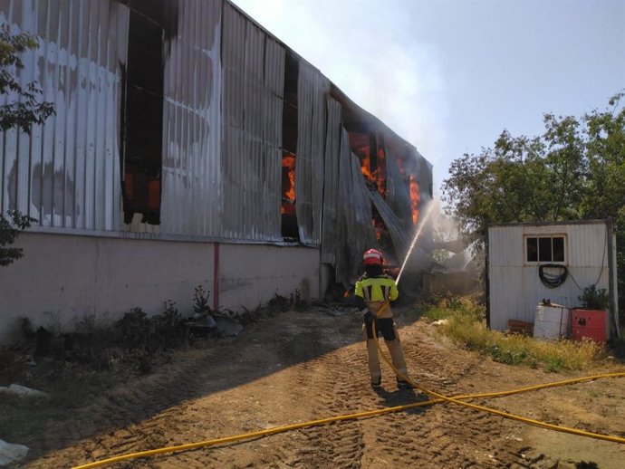 Bombero de la DPH extinguiendo el fuego en una nave agrícola.