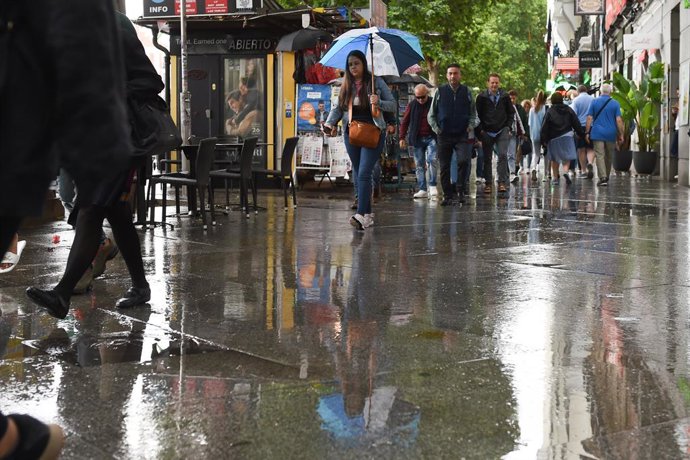 Varias personas pasean bajo la lluvia, a 23 de mayo de 2023, en Madrid (España). La Agencia Estatal de Meteorología (Aemet) prevé lluvias en la región madrileña todo lo que queda de semana ocasionadas por una DANA (Depresión Aislada en Niveles Altos) qu