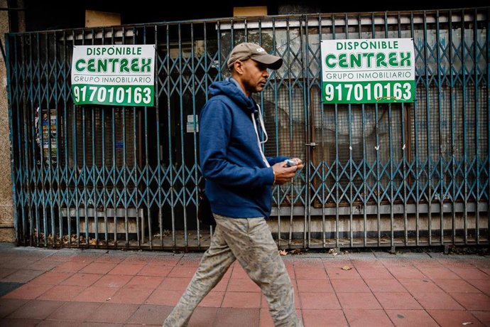 Archivo - Un hombre pasa al lado de una tienda cerrada, a 27 de octubre de 2022, en Madrid (España). El paro ha subido en 60.800 personas entre julio y septiembre, lo que supone casi un 2,1% más que en el trimestre anterior, mientras que la ocupación se