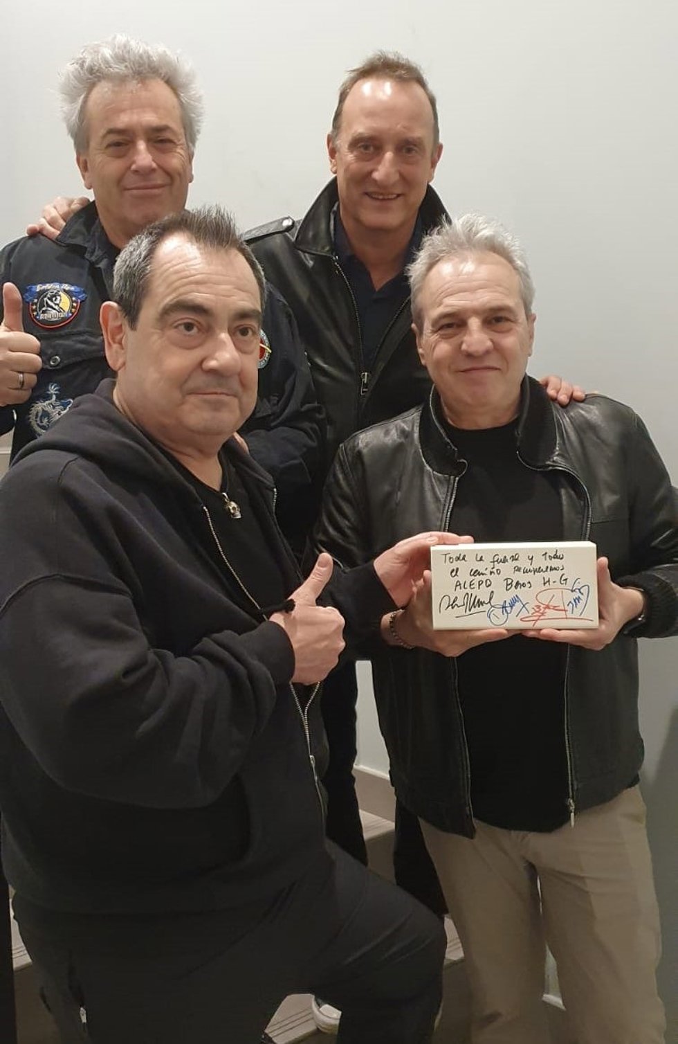 El grupo de música Los Hombres G firma uno de los ladrillos para la subasta de la ONG Rescate, que será subastado con el objetivo de conseguir fondos para la recostrucción de la ciudad de Alepo (Siria).