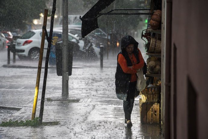 Una mujer con paraguas bajo la lluvia, a 29 de mayo de 2023, en Madrid (España). La Agencia Estatal de Meteorología (Aemet) ha avisado de la alerta naranja en Madrid por la tormenta que ha dejado varias incidencias en la tarde de hoy. Las fuertes lluvia