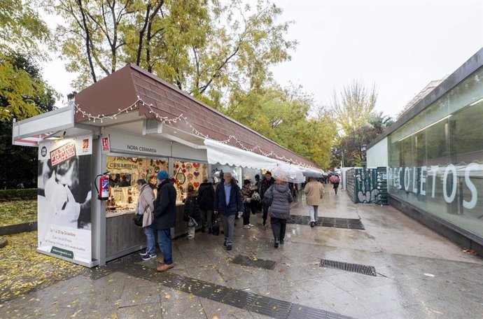 Archivo - Varias personas visitan los puestos en la 36 edición de la Feria Mercado de Artesanía,  a pesar de la lluvia, en el Paseo de Recoletos, a 8 de diciembre de 2022, en Madrid (España). 