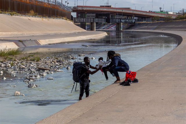 Archivo - Una familia de migrantes en la frontera entre México y Estados Unidos