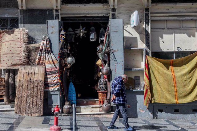 Archivo - Un hombre camina por una calle con tiendas, en Tánger