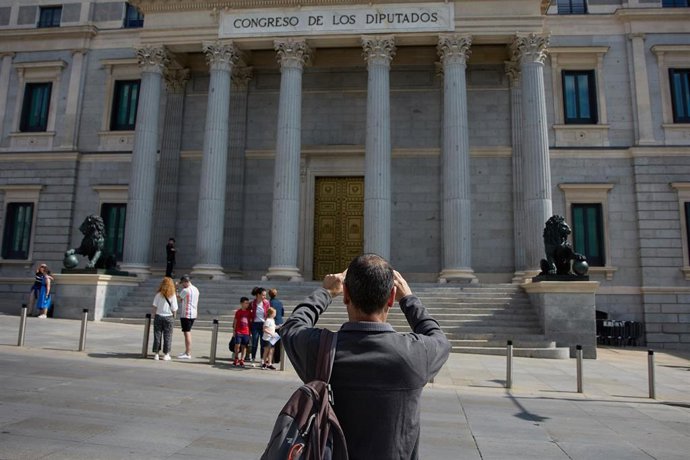 Un turista toma fotografías frente al Congreso de los Diputados