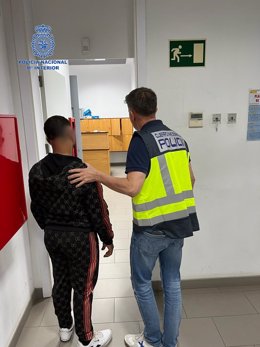 Un agente de la Policía Nacional con uno de los cuatro varones detenidos por darle una paliza a un taxista y causar daños en el vehículo en Palma