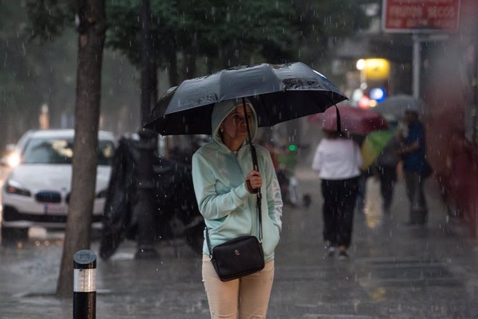 Una mujer con paraguas bajo la lluvia en Madrid (España). 