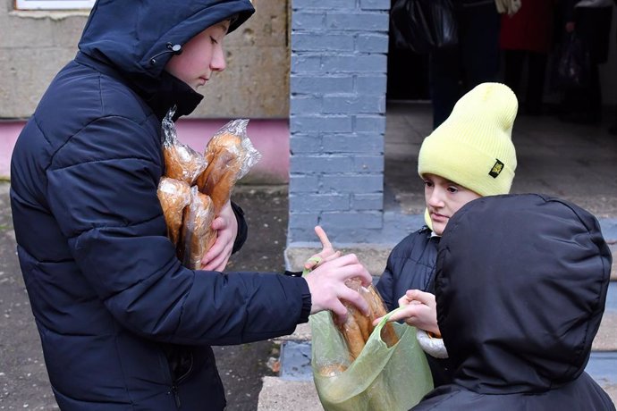 Archivo - December 24, 2022, Kramatorsk, Donetsk, Ukraine: Children receive bread at a humanitarian aid distribution point in Kramatorsk. Russian forces keep pounding critical power infrastructure in Ukrainian cities, killing more civilians and leaving 