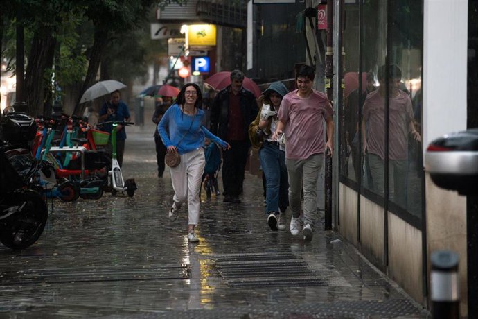 Varias personas caminan bajo la lluvia, a 29 de mayo de 2023, en Madrid (España). 