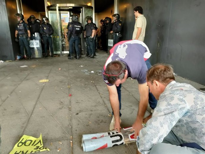 Ganaderos recogen una pancarta ante la sede de la Delegación de la Junta en Salamanca con la presencia de la Policía Nacional.
