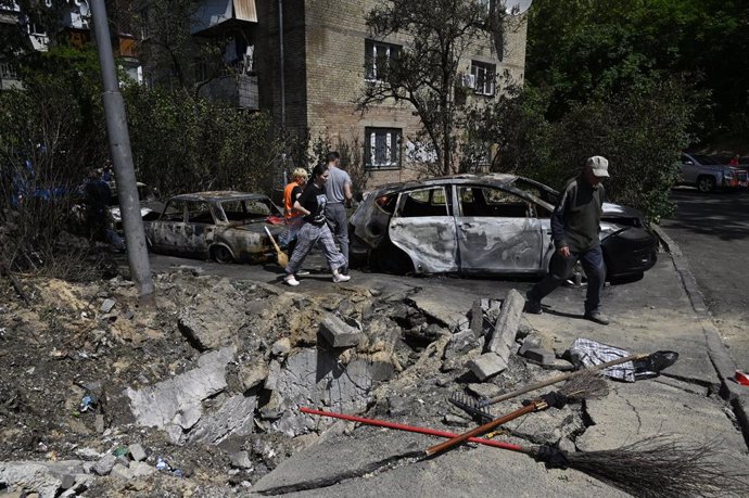 30 May 2023, Ukraine, Kiev: People inspect their damaged cars following a drone attack by the Russian army. Russian airstrikes targeted Kiev for the third night in a row, killing one person, the military administration of the Ukrainian capital said on T