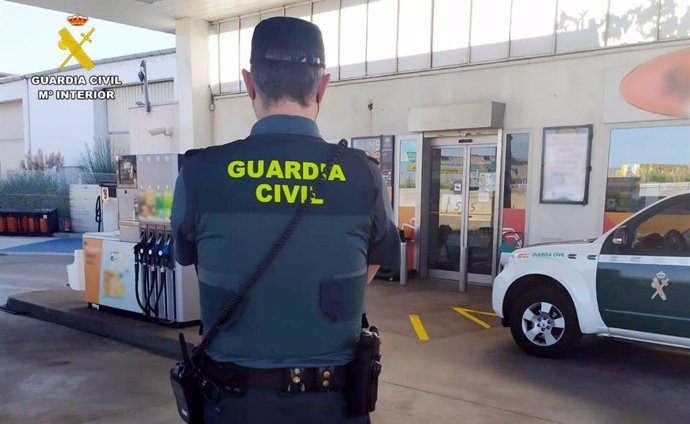 Un guardia Civil frente a una gasolinera.