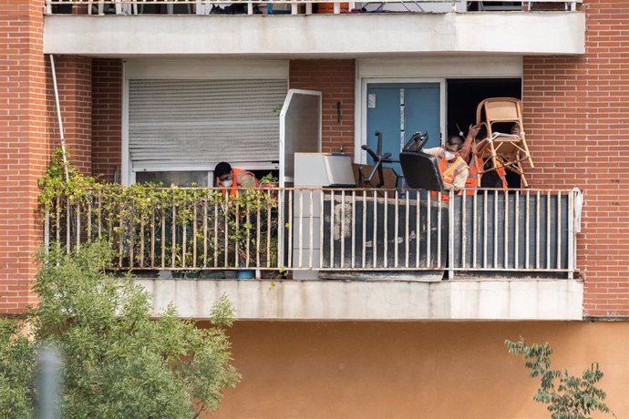 Trabajadores sacan al balcón de un domicilio las pertenencias de las 62 familias que han desalojado de cuatro portales, a 2 de junio de 2023, en Alcobendas, Madrid (España).