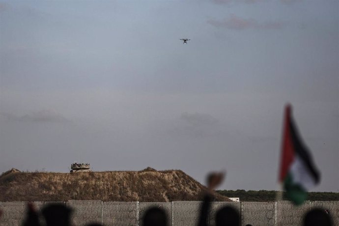 18 May 2023, Palestinian Territories, Gaza city: A drone flies as Palestinians take part in a 'flag march' along the border with Israel east of Gaza City in response to Jerusalem Day, an annual event during which Israeli nationalists celebrate the Israe