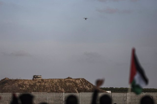 18 May 2023, Palestinian Territories, Gaza city: A drone flies as Palestinians take part in a 'flag march' along the border with Israel east of Gaza City in response to Jerusalem Day, an annual event during which Israeli nationalists celebrate the Israeli
