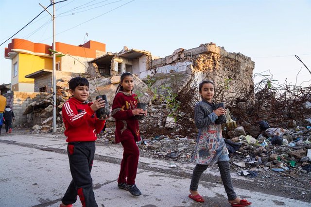 Archivo - December 24, 2021, Mosul, Iraq: Children hold trees after a man dressed as Santa Claus distribute to them near the rubble in the old town of Mosul..An initiative launched by Iraqi volunteers from the Mosul Eye Foundation to plant thousands of tr