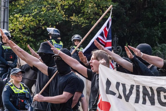 May 13, 2023, Melbourne, Australia: Neo-Nazis protesters with flags salute as they are ordered to leave the area during the demonstration. A day of political tensions and clashes unfolded in Melbourne as far-right a Neo-Nazi group held an anti-immigrati