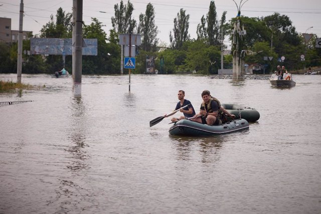 HANDOUT - 08 June 2023, Ukraine, Kherson: Emergency forces use a float boat to evacuate residents trapped in the water at Kherson.
