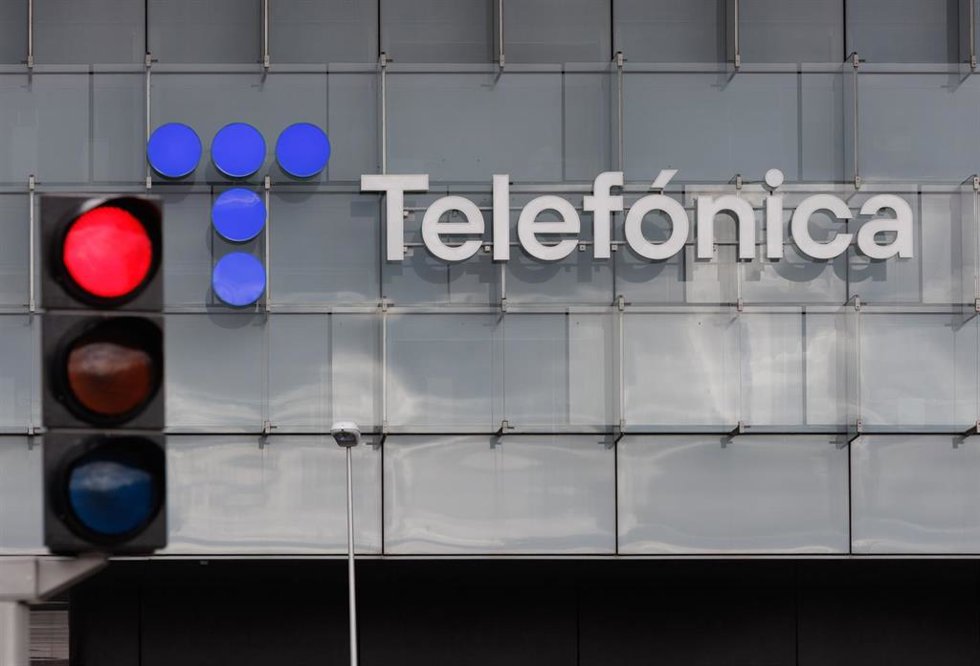 Archivo - Un semáforo en rojo frente a la fachada de la sede de Telefónica