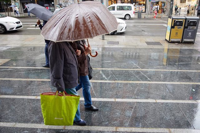 Dos persones amb paraigües, caminen sota la pluja pel centre de Madrid, a 7 de juny del 2023, a Madrid (Espanya). 