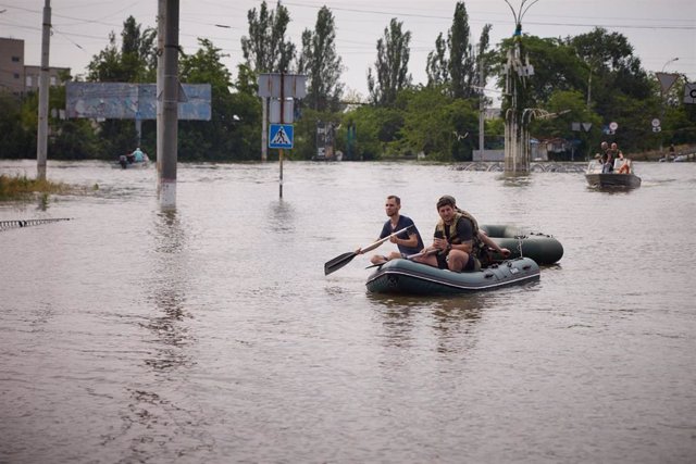 Las fuerzas de emergencia de Ucrania utilizan un bote flotador para evacuar a los residentes atrapados en el agua en Jersón