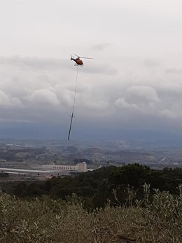 El helicóptero trasladando uno de los soportes en los trabajos realizados por Endesa.