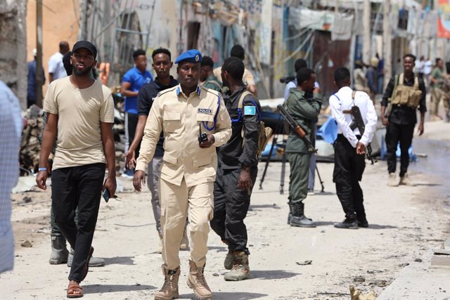 MOGADISHU, Aug. 22, 2022  -- Policemen stand guard near the site of a terrorist attack in Mogadishu, Somali on Aug. 21, 2022. Somali government confirmed Sunday that 21 people were killed in the terrorist attack on a popular hotel in the Somali capital Mo