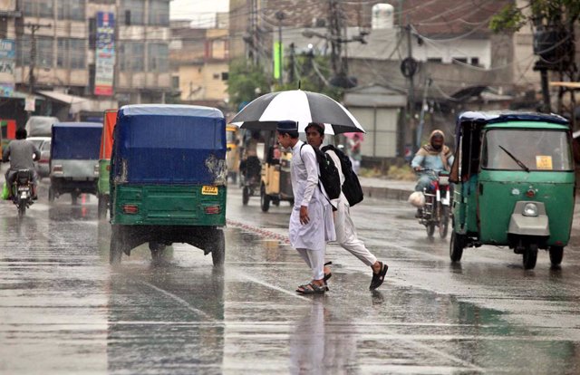 June 1, 2023, Pakistan: PESHAWAR, PAKISTAN, JUN 01: School boys using umbrella to protect from rain during the .downpour of summer season, in Peshawar on Thursday, June 1, 2023.