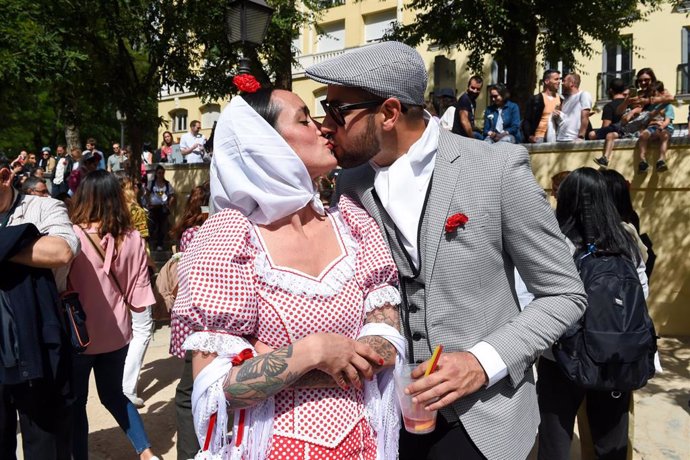 Una pareja de chulapos luce claveles rojos y se besan en Las Vistillas, a 13 de mayo de 2023