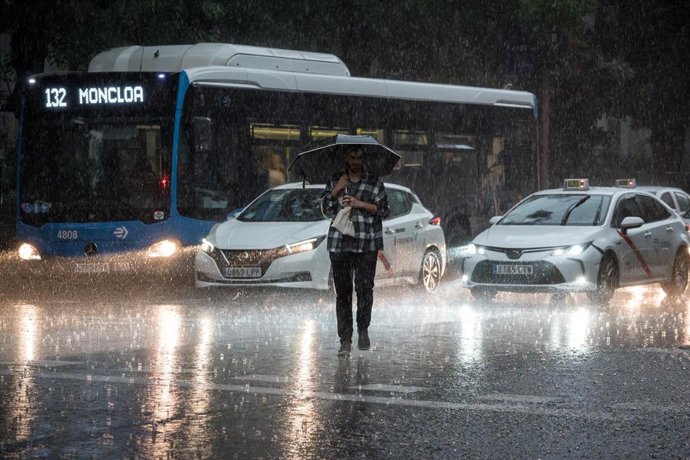 Una persona cruza la calle bajo la lluvia, a 29 de mayo de 2023, en Madrid (España).   
