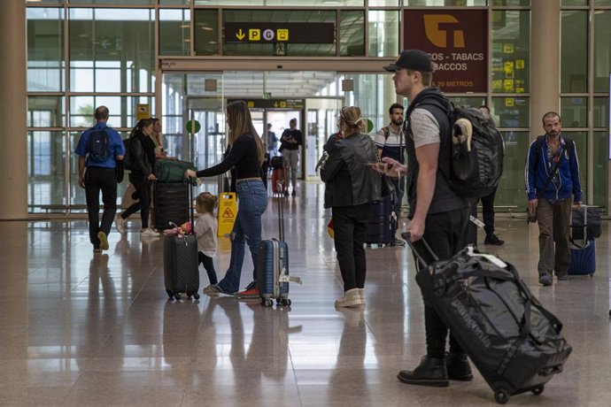 Archivo - Un grupo de personas con maletas en el aeropuerto de Barcelona.