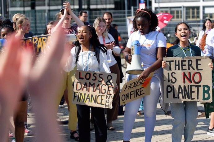 09 June 2023, North Rhine-Westphalia, Bonn: Participants hold placards during protests by the climate protection movement Fridays for Future at the interim negotiations for the next world climate conference underway in Bonn. Photo: Henning Kaiser/dpa