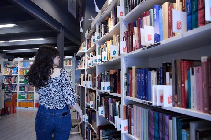 Archivo - Una mujer mira las estanterías en una librería, foto de recurso