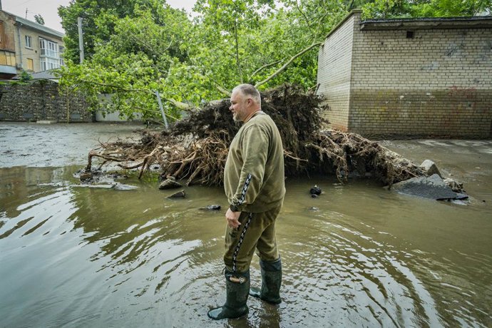 June 12, 2023, Kherson, Ukraine: A man is walking in the water near the roots of a huge tree fallen by the flooding of the Dnipro River due to the destruction of the Nova Kakhovka dam upstream in Nova Kakhovka, Ukraine, on June 8, 2020.