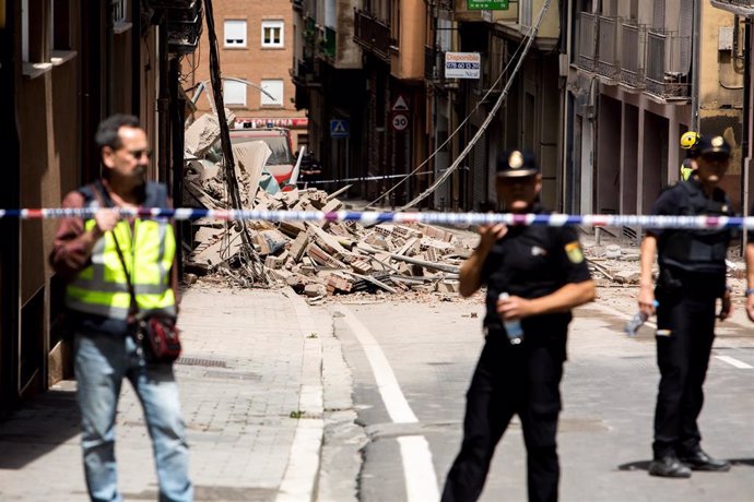 Agentes de Policía Nacional frente al estado en el que ha quedado un edificio de cinco plantas situado en la calle San Francisco de Teruel tras derrumbarse por completo.