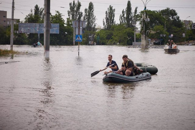 Una barca navega por una zona inundada de Jersón tras la destrucción de una presa