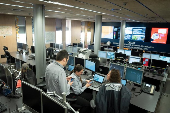 Archivo - Trabajadores del equipo de Protecció Civil durante una prueba de envío masivo de mensajes a teléfonos móviles inteligentes para alertar de emergencias, en la sala de mandos del CECAT (Centro de Coordinación Operativa de Catalunya)