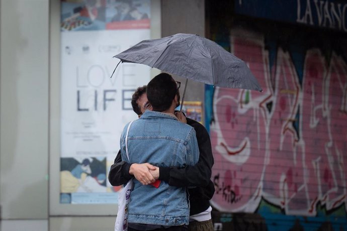 Archivo - Dos personas se abrazan bajo un paraguas, a 12 de mayo de 2023, en Barcelona, Catalunya (España).