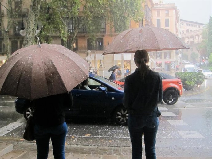 Archivo - Dos personas con paraguas para cubrirse de la fuerte lluvia en el Paseo del Borne de Palma.