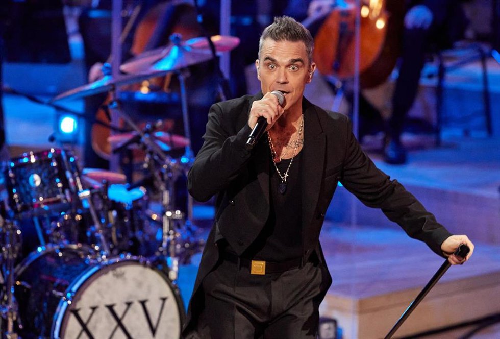 Archivo - 15 November 2022, Hamburg: British singer Robbie Williams and musicians of the New Philharmonic Orchestra Frankfurt perform on stage during a live concert in the Great Hall at the Elbphilharmonie. Williams gave a concert to celebrate 25 years 